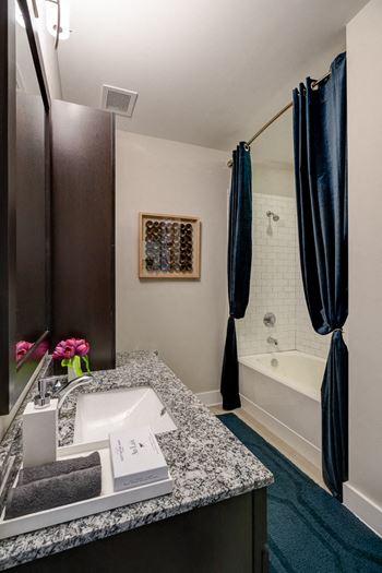 Master bathroom with floating vanities, quartz countertops, backlit vanity mirror, walk-in shower with euro shower door and quartz-topped bench seat